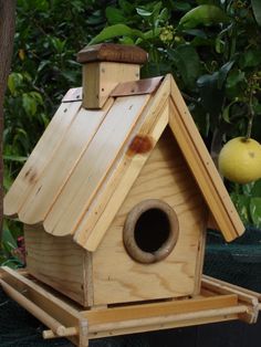 a wooden birdhouse sitting on top of a tree