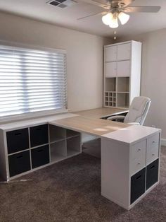 an empty room with a desk and shelves in it, along with a ceiling fan