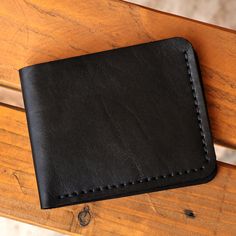 Made for a practical lifestyle, Irina Sargsyan's newest bifold leather wallet mesmerizes with its dapper minimalist design. Equipped with four card slots and a generous compartment for bills, this elegant accessory is perfect for casual or professional ambiences thanks to its sublime obsidian hue. Modern Bifold Wallet As Gift, Modern Bifold Wallet For Gift, Minimalist Black Trifold Wallet As Gift, Black Smooth Grain Wallet As Gift, Minimalist Bifold Wallet For Formal Occasions, Minimalist Bifold Wallets For Everyday Carry, Minimalist Everyday Bifold Wallet, Everyday Bifold Wallets With Leather Lining, Bifold Wallets For Daily Use