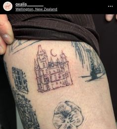 a person with a tattoo on their thigh that has an image of a castle and clover