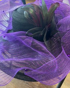 A nice classy way to wear a  Black and Purple Hat for the Spring or the Summer. This hat can be worn to a tea party or church.This beautiful hat can be worn in so many different ways. The art and design is one of a kind.Don't delay order yours today. Elegant Black Cloche Hat For Party, Elegant Black Fedora Mini Hat, Elegant Fedora Mini Hat For Church, Elegant Fedora For Church, Elegant Black Mini Fedora Hat, Elegant Purple Top Hat With Curved Brim, Purple Formal Hat For Kentucky Derby, Chic Purple Hat For Kentucky Derby, Purple Fedora Hat For Party