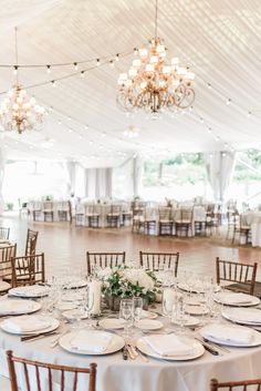 the tables are set with place settings and centerpieces for an elegant wedding reception