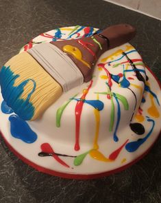 a cake decorated with paint and a brush