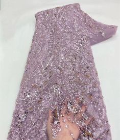 someone is holding onto the purple sequins on top of a piece of cloth