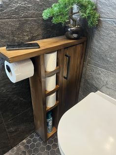 a bathroom with a toilet, sink and wooden cabinet next to a roll of toilet paper