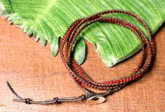 Wrap Bracelets with red glass beads. Brown leather wraps around red glass beads with a brass button clasp. Unwrap and wear long as a necklace or wrap as an anklet. 21 – 22″ in length, 4.5mm in width Red Adjustable Bohemian Wrap Bracelet, Handmade Adjustable Red Wrap Bracelet, Adjustable Red Wire-wrapped Jewelry, Adjustable Wire Wrapped Red Jewelry, Adjustable Red Handmade Wrap Bracelet, Adjustable Red Wire Wrapped Jewelry, Red Adjustable Wire Wrapped Bracelets, Adjustable Red Wire Wrapped Bracelets, Adjustable Red Wire Wrapped Bracelet