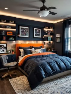 a bedroom with blue and orange bedding, pictures on the wall, and a ceiling fan