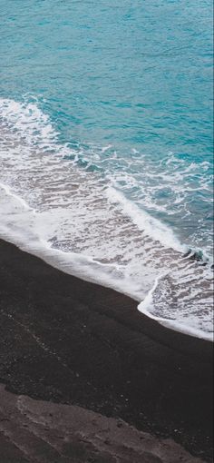 two people walking on the beach with an umbrella