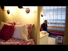 a man sitting on top of a bed next to a window