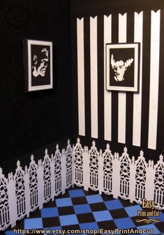 a black and white striped room with pictures on the wall, checkerboard floor