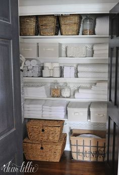 an organized closet with baskets and towels