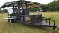 a trailer with a food cart attached to it in the middle of a grassy field