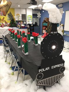 a polar express train is on display in the snow with santa's hats and stockings