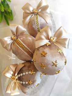 three christmas ornaments with bows and pearls on them