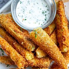 some fried food is on a plate with ranch dip in the middle next to it