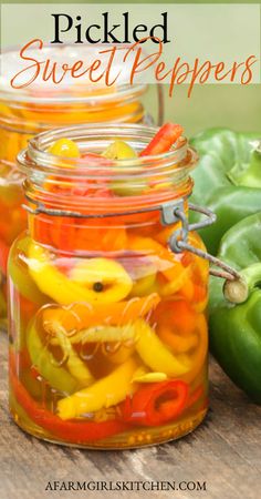 jars filled with pickled sweet peppers sitting on top of a wooden table next to green peppers