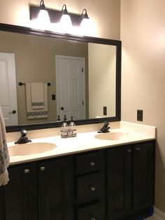 a bathroom with two sinks and a large mirror