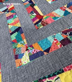 a close up of a patchwork quilt with many different colors and patterns on it