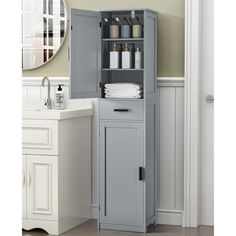 a bathroom cabinet with towels and soaps on it in front of a white sink