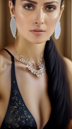 a woman in a black dress with large earrings on her head and long dark hair