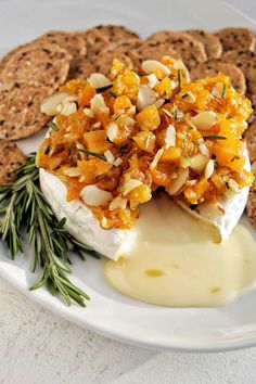 apricot jam baked brie with crackers on the side and rosemary sprigs