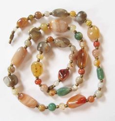 This is a gorgeous natural agate beaded necklace from the 1970's at my best estimate. The necklace is not marked or signed, but these pieces were very popular in the 1960's and 1970's. The necklace is 24 inches long. The largest agate bead is 7/8 inch by 1/2 inches.  The small round agates are 7 mm. The beads are spaced with tiny brass spacer beads. The necklace is in very good condition. The agates are free of chips, cracks, scratches, or scuffs. The brass barrel clasp functions well. The only Handmade Vintage Agate Beaded Necklaces, Vintage Handmade Agate Beaded Necklaces, Vintage Agate Beaded Necklaces, Vintage Agate Necklaces With Colorful Beads, Vintage Agate Necklace With Colorful Beads, Vintage Agate Beaded Necklaces With Large Beads, Vintage Agate Necklaces With Polished Beads, Vintage Agate Beaded Necklace With Large Beads, Vintage Agate Round Beads For Jewelry