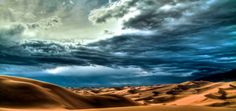 the sky is full of clouds and sand dunes