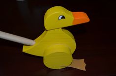 a wooden toy duck sitting on top of a table