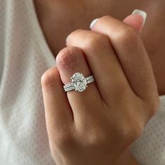 a close up of a person wearing a ring with a diamond on the middle finger