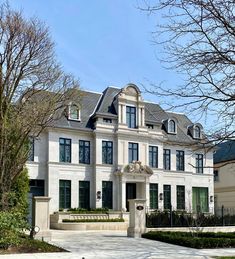 a large white house with lots of windows on it's front door and side entrance