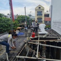 some people are working on the roof of a building that is being built with steel bars