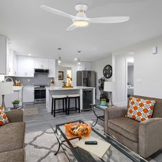 a living room filled with furniture next to a kitchen