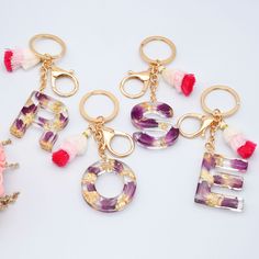 four different types of keychains with tassels and charms on them,