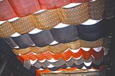 many different colored baskets hanging from the ceiling