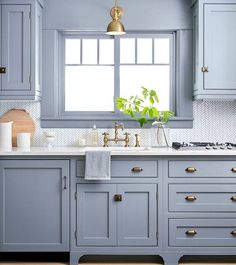 a kitchen with blue cabinets and rug in the middle