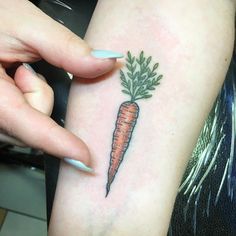 a woman's arm with a carrot tattoo on the left side of her body