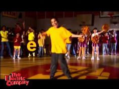 a man in yellow shirt standing on top of a basketball court next to other people