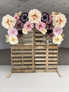 an arrangement of paper flowers in a wooden crate