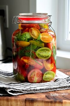 a glass jar filled with sliced tomatoes and cucumbers