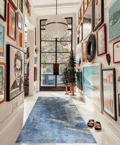 the hallway is decorated with art and pictures on the wall, along with a blue rug