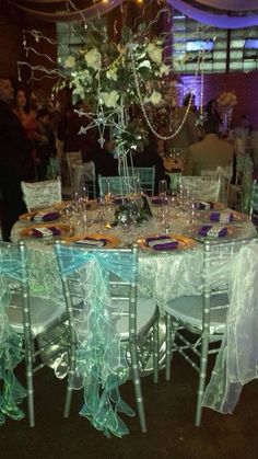 the table is set for an event with white and blue decorations