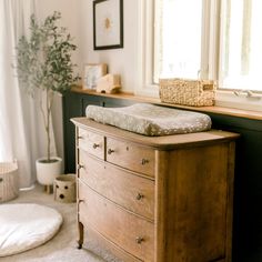 a wooden dresser sitting next to a window