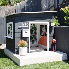 a small gray and white shed with a red flamingo