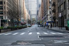 an empty city street with buildings in the back ground and signs painted on the road