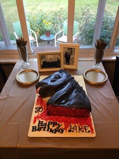 a birthday cake that looks like a horse head is on a table in front of a window