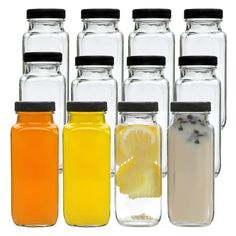 six jars filled with different colored liquids next to each other on a white background