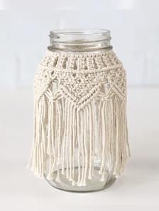 a mason jar filled with tassels on top of a table