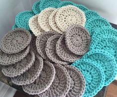 several crocheted coasters on top of a wooden table with white and gray circles