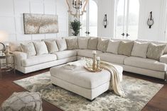 a living room filled with furniture and a large rug on top of a wooden floor