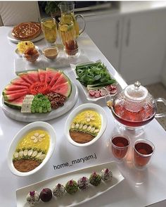 a table topped with plates and bowls filled with different types of food next to drinks